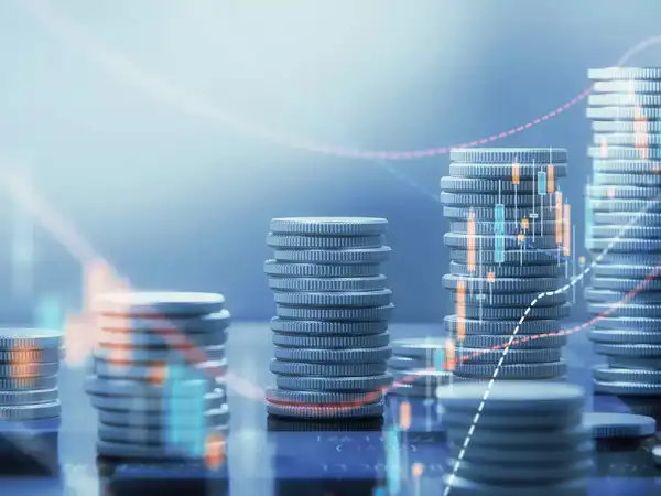 Stacks of coins with an upward financial growth graph.